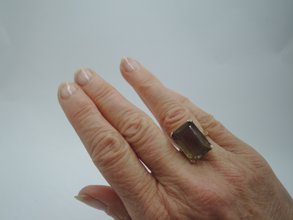 An oversized smoky quartz ring in a raised four claw basket mount on a yellow metal loop stamped - Image 2 of 3