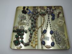 A tray of vintage and later costume jewellery including strings of beads, diamante brooches,
