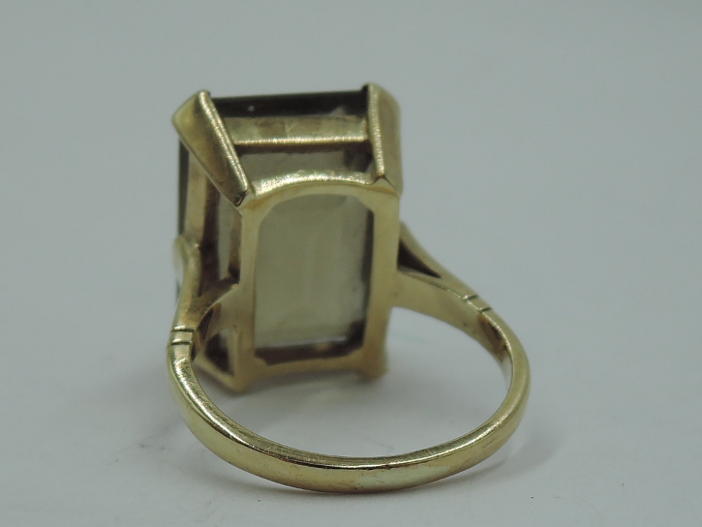 An oversized smoky quartz ring in a raised four claw basket mount on a yellow metal loop stamped - Image 3 of 3