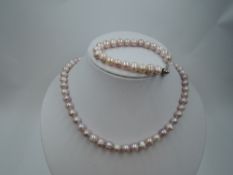 A string of pink baroque pearls with matching bracelet by Teng Yue, approx 17' & 7'
