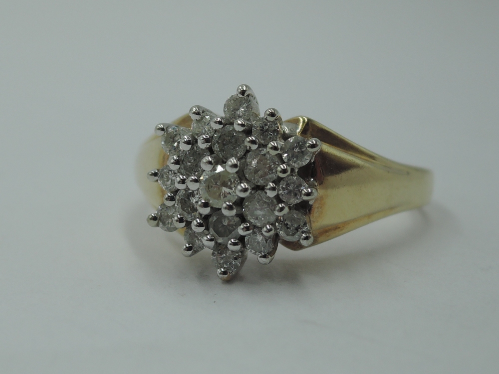 A lady's dress ring having a diamond chip triple cluster in a stepped mount to shaped shoulders on a