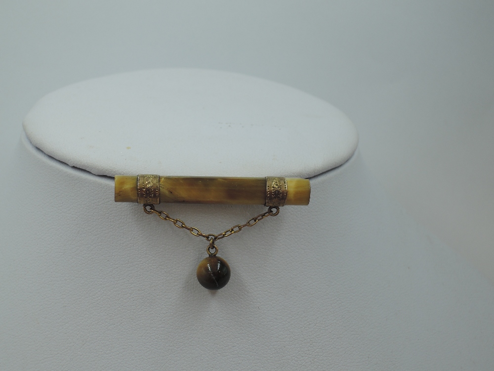 A vintage tigers eye bar brooch having yellow metal bands with chain connecter to tigers eye bead - Image 2 of 2