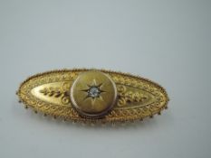A Victorian yellow metal brooch stamped 15ct having a central old cut diamond, approx 0.064ct in a