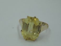 A golden beryl style solitaire ring of octagonal form in an eight claw mount with raised shoulders