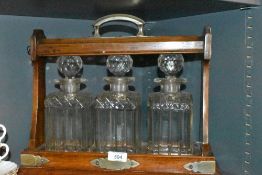 an antique oak cased tantalus having a set of cut decanters