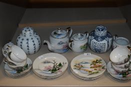 A partial Japanese tea service having cup and saucers, tea pot and more.