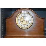 An antique mahogany cased mantle clock with a brass and enamel faced dial