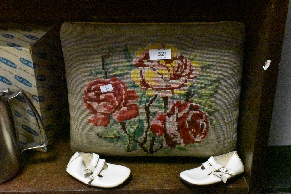 A traditional oak foot stool having embroidered top and a pair of childs white leather shoes