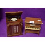 Two miniature model music boxes one styled as a piano and similar jukebox
