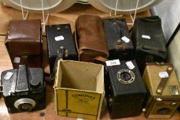 A collection of vintage cameras including Ilford Envoy, Coronet box camera, Kodak Brownie and more.