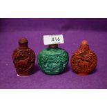 Three Chinese cinnabar styled snuff bottles having naturalistic animal decorations