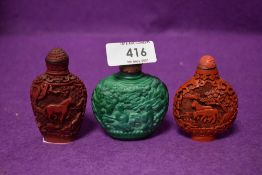 Three Chinese cinnabar styled snuff bottles having naturalistic animal decorations