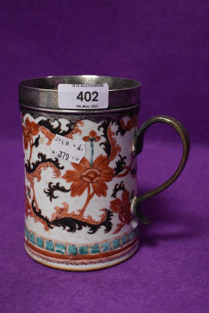 An antique hard paste porcelain ale or similar mug having Imari styled palette HM white metal rim