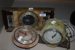 Three vintage onyx and brass mantel clocks.