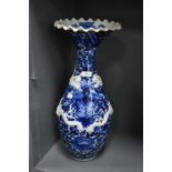 A large standing blue and white wear Chinese vase having raised dragon motif and scalloped rim