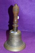 A large brass and oak handled wardens or similar hand bell