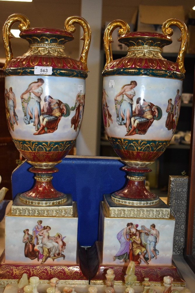 A large pair of impressive urns, thought to be Royal Vienna having heavy and ornate gilt detailing