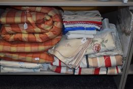 A shelf full of textiles including Laura Ashley curtains,table linen and more.