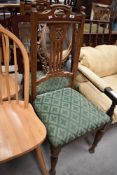 A pair of early 20th Century oak dining chairs having overstuffed seats