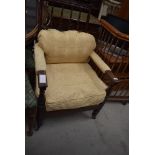 A Victorian mahogany spindle back easy armchair having later lemon upholstery