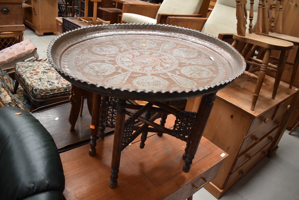 An Eastern copper tray, diameter approx. 70cm, on turned wood frame