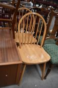 A pair of rubber wood hoop and stick back dining chairs