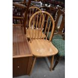 A pair of rubber wood hoop and stick back dining chairs