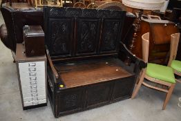 A 19th Century dark oak box settle having carved high panel back