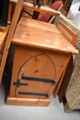 A pair of modern pine bedside cabinets having gothic style doors and cast hardware