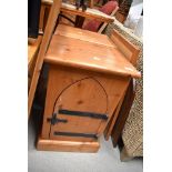 A pair of modern pine bedside cabinets having gothic style doors and cast hardware