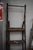 A set of fold away metal framed wooden step ladders