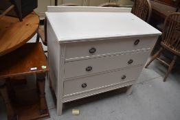 A chest of three drawers in painted pine