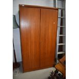 A vintage teak wardrobe having partially fitted interior