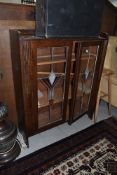 An early 20th Century oak bookcase having leaded glass doors in the Art Deco style