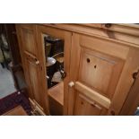 A natural pine mirror door wardrobe, having drawer base, width approx. 150cm