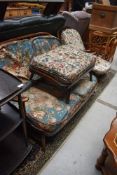 A dark stained Ercol cottage suite comprising settee, chair and footstool