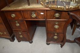 A late Victorian small proportioned desk having flame mahogany fronted draws leather top and bun