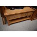 A modern golden oak coffee table/TV stand with drawers and undershelf