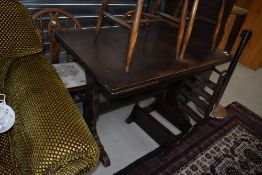 A dark stained Ercol style drawer leaf dining table