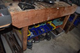 A pine work bench having fixed black and decker drill and under shelf