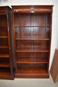 An Oriental hardwood bookcase having concealed upper drawer