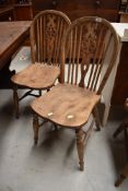 A pair of kitchen chairs with wheel backs on elm wood eats
