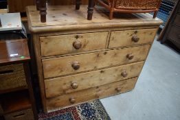 A stripped pine chest of two over three drawers