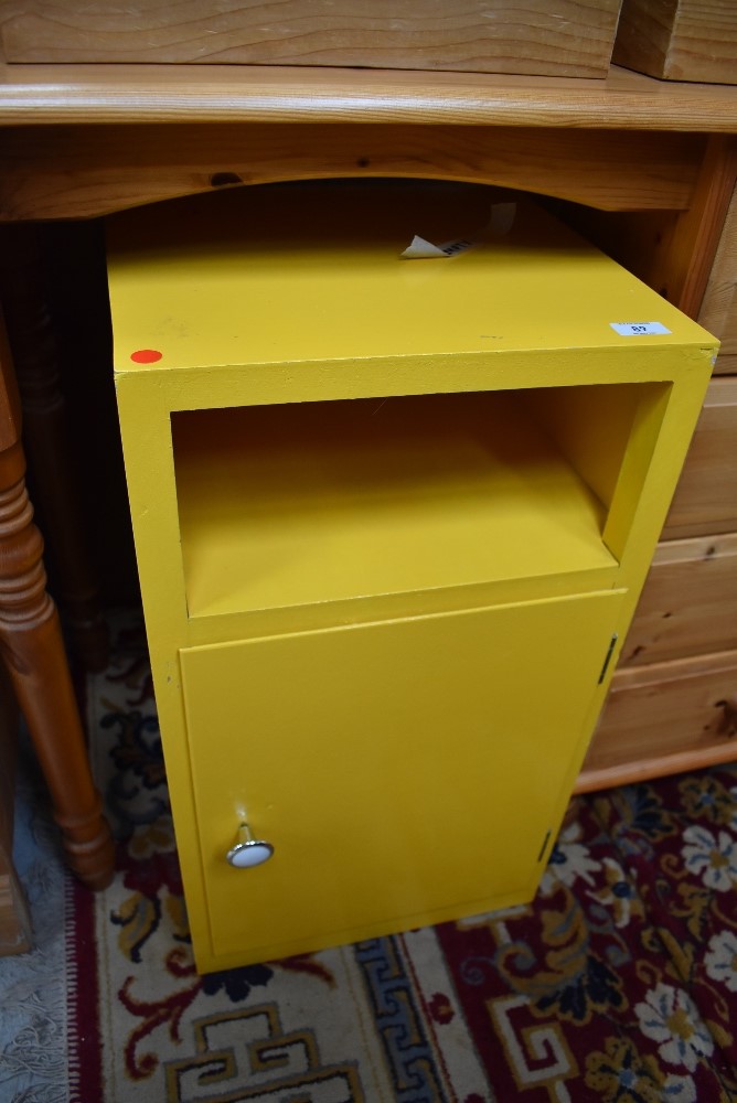 A vintage painted ply bedside cabinet, in yellow