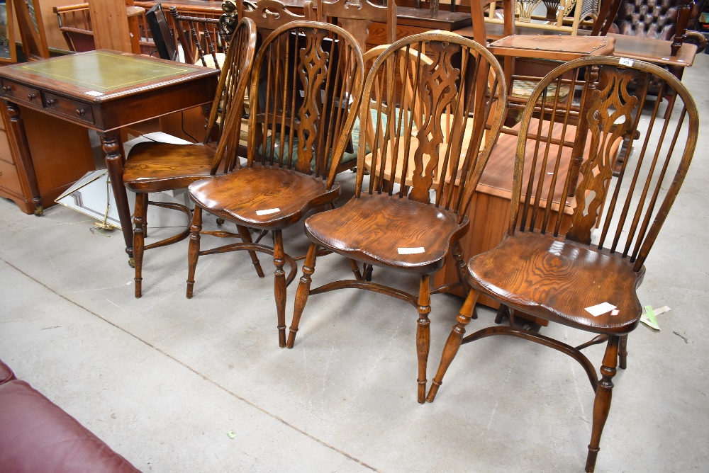 A set of four elm Vernacular solid seat spindle and vase back chairs having crinoline strecthers