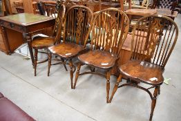 A set of four elm Vernacular solid seat spindle and vase back chairs having crinoline strecthers
