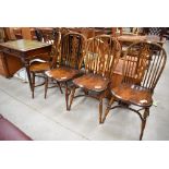 A set of four elm Vernacular solid seat spindle and vase back chairs having crinoline strecthers