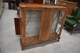 An art deco display cabinet having glazed front and glass shelving