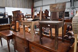 A pair of rustic oak chairs having leather seats and bent ply backs, possibly from railway waiting