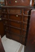 A dark stained Priory style chest of five drawers and a dressing table